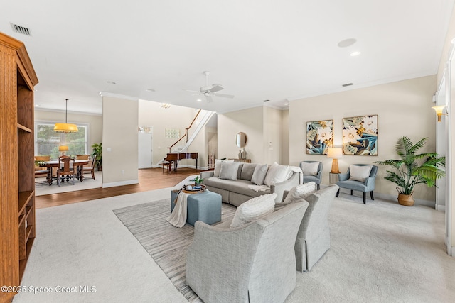 430 Monaco Dr, Indialantic, FL 32903 - living room featuring ornamental molding, stairway, ceiling fan, light colored carpet, and baseboards