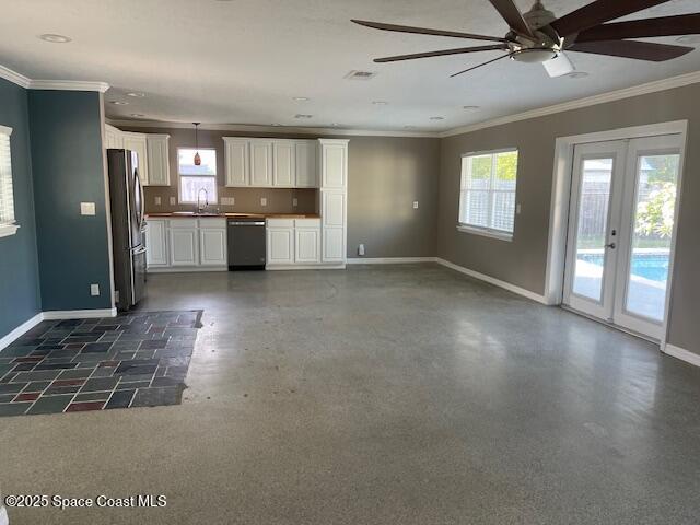 kitchen with dishwashing machine, freestanding refrigerator, healthy amount of natural light, baseboards, and crown molding