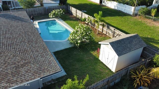 view of swimming pool featuring a storage shed and an outbuilding