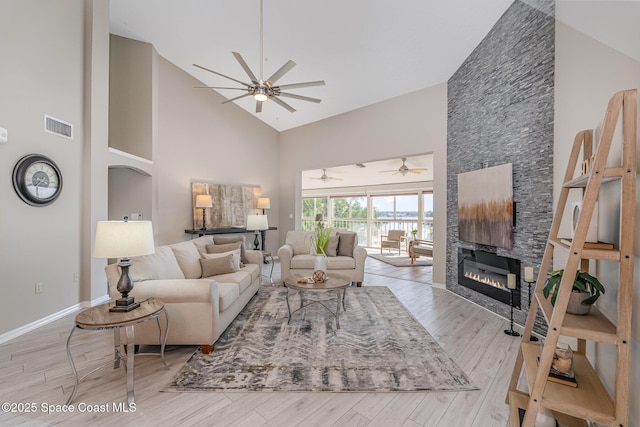 343 N Tropical Trl Unit 404, Merritt Island, FL 32953 - living area with high vaulted ceiling, a ceiling fan, light wood-type flooring, a fireplace, and baseboards