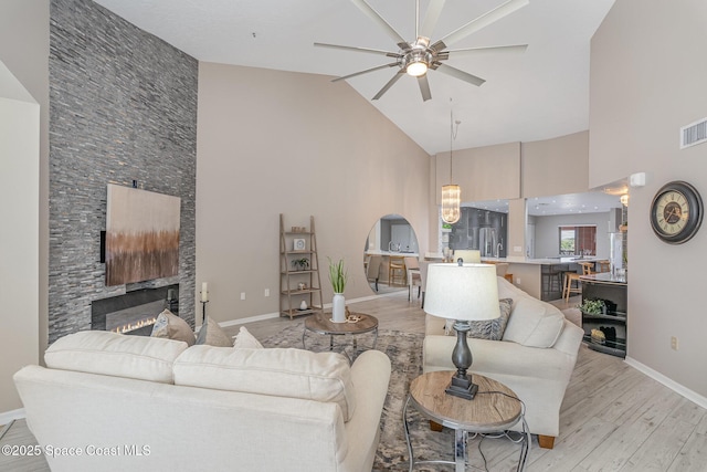 343 N Tropical Trl Unit 404, Merritt Island, FL 32953 - living room featuring high vaulted ceiling, ceiling fan, light wood finished floors, a fireplace, and baseboards