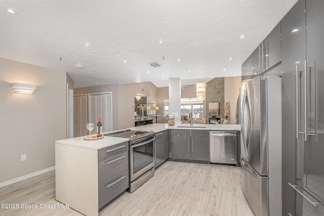 343 N Tropical Trl Unit 404, Merritt Island, FL 32953 - kitchen with stainless steel appliances, a sink, gray cabinets, modern cabinets, and light wood finished floors