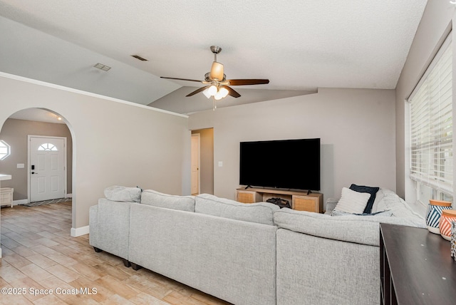 2040 Lansing St, Melbourne, FL 32935 - living room featuring arched walkways, ceiling fan, light wood-type flooring, lofted ceiling, and baseboards