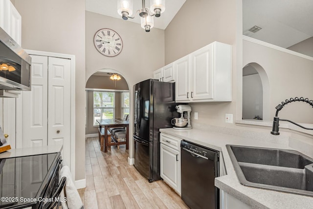 2040 Lansing St, Melbourne, FL 32935 - kitchen featuring black dishwasher, a sink, arched walkways, white cabinetry, and light countertops