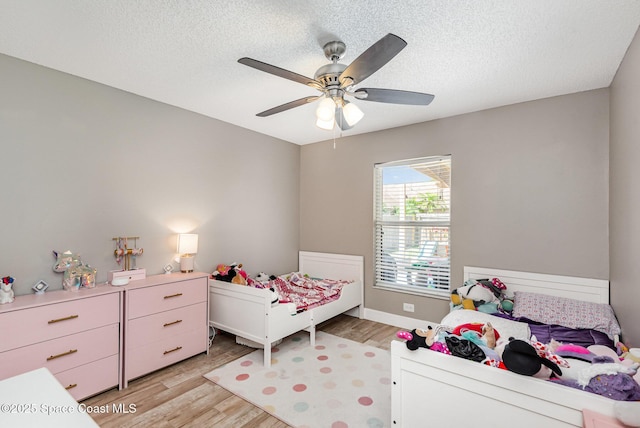 2040 Lansing St, Melbourne, FL 32935 - bedroom featuring light wood-style floors, a textured ceiling, a ceiling fan, and baseboards