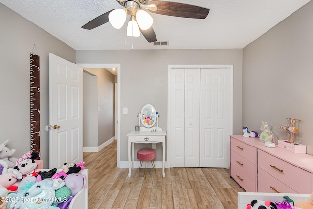 2040 Lansing St, Melbourne, FL 32935 - bedroom featuring light wood finished floors, a closet, a ceiling fan, baseboards, and a textured ceiling