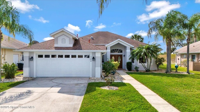 2268 Brightwood Cir, Rockledge, FL 32955 - view of front of house featuring stucco siding, an attached garage, a front yard, concrete driveway, and roof with shingles