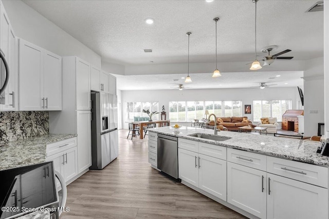 2268 Brightwood Cir, Rockledge, FL 32955 - kitchen featuring appliances with stainless steel finishes, a sink, a textured ceiling, a ceiling fan, and white cabinetry