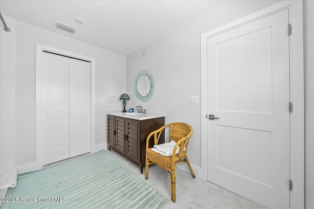 living area with a textured ceiling and baseboards