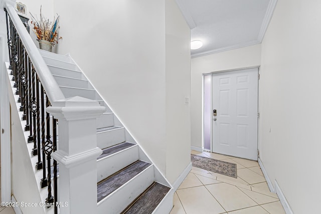 165 Escambia Ln Unit 502, Cocoa Beach, FL 32931 - foyer featuring crown molding, stairs, light tile patterned floors, and baseboards