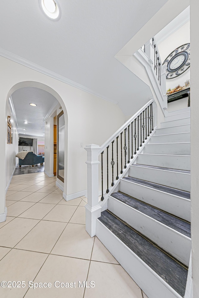 165 Escambia Ln Unit 502, Cocoa Beach, FL 32931 - stairs featuring tile patterned floors, crown molding, arched walkways, baseboards, and recessed lighting