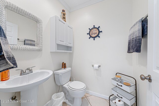 165 Escambia Ln Unit 502, Cocoa Beach, FL 32931 - half bath featuring toilet, tile patterned flooring, crown molding, baseboards, and a sink