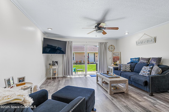 165 Escambia Ln Unit 502, Cocoa Beach, FL 32931 - living room featuring ornamental molding, ceiling fan, wood finished floors, a textured ceiling, and baseboards