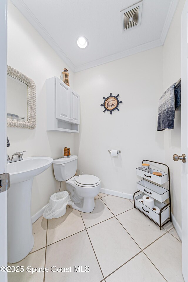 165 Escambia Ln Unit 502, Cocoa Beach, FL 32931 - half bathroom featuring toilet, baseboards, ornamental molding, and tile patterned floors