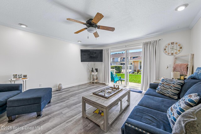 165 Escambia Ln Unit 502, Cocoa Beach, FL 32931 - living area with wood finished floors, ceiling fan, crown molding, baseboards, and a textured ceiling
