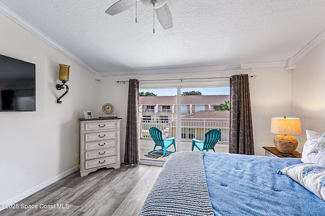 165 Escambia Ln Unit 502, Cocoa Beach, FL 32931 - bedroom featuring ornamental molding, wood finished floors, access to exterior, a textured ceiling, and baseboards