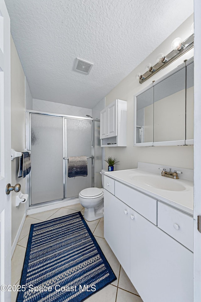 165 Escambia Ln Unit 502, Cocoa Beach, FL 32931 - bathroom with tile patterned floors, a shower stall, toilet, vanity, and a textured ceiling
