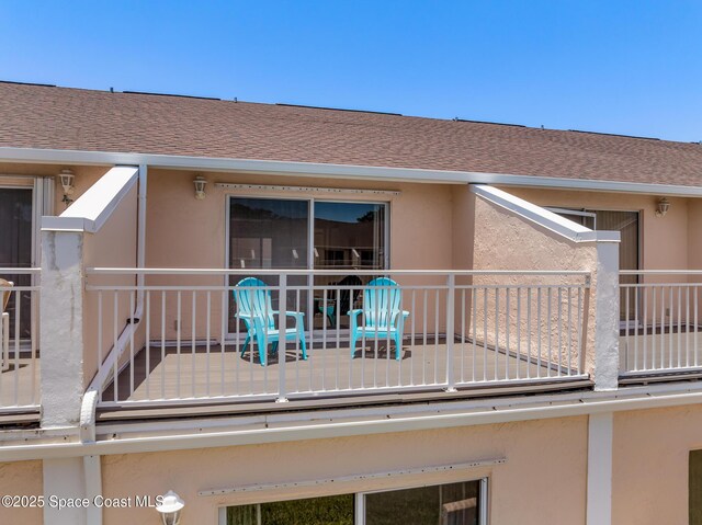 165 Escambia Ln Unit 502, Cocoa Beach, FL 32931 - rear view of house with a balcony, stucco siding, and a shingled roof