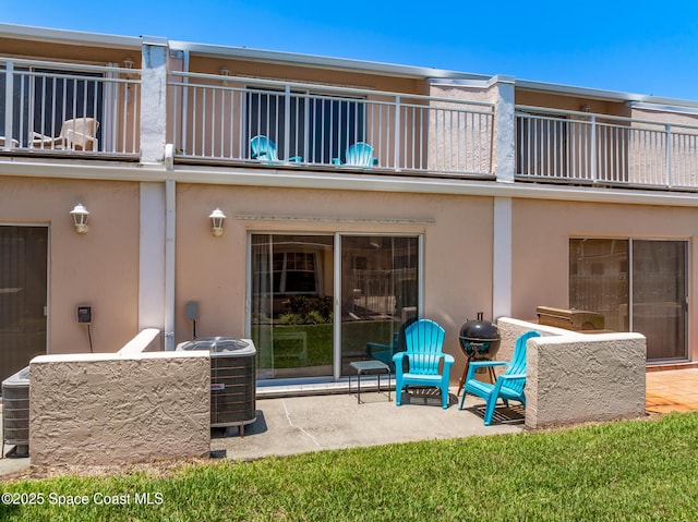 165 Escambia Ln Unit 502, Cocoa Beach, FL 32931 - rear view of house with a balcony, a patio area, central AC, and stucco siding