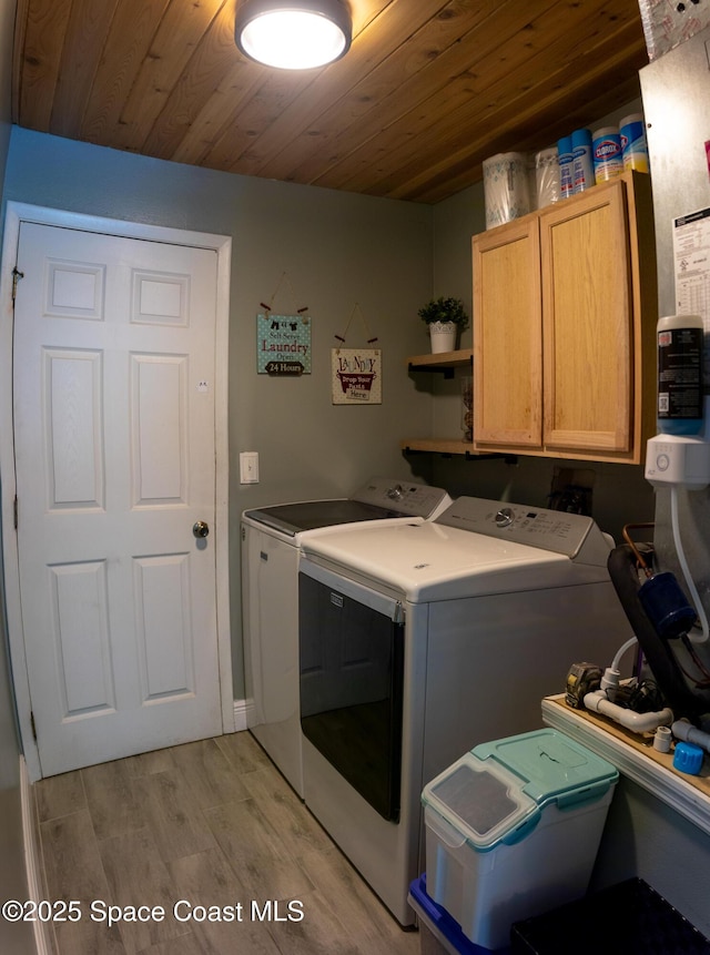 886 Spirea Dr, Rockledge, FL 32955 - laundry room featuring washer and dryer, cabinet space, light wood-style flooring, and wooden ceiling