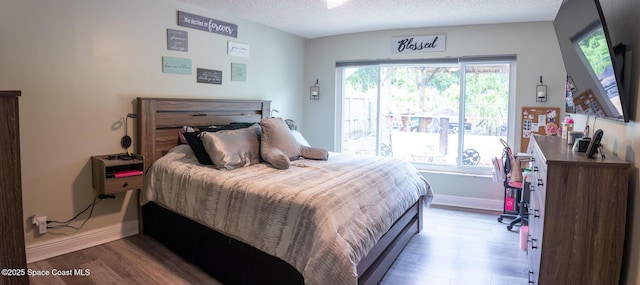 886 Spirea Dr, Rockledge, FL 32955 - bedroom featuring wood finished floors, a textured ceiling, and baseboards