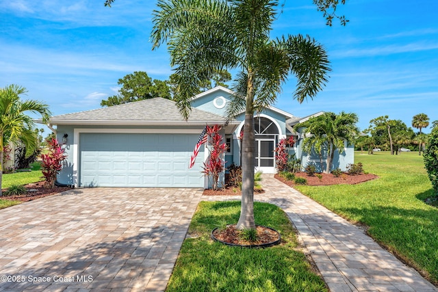 2102 Durban Ct, Rockledge, FL 32955 - view of front of home featuring decorative driveway, a front lawn, a garage, and stucco siding