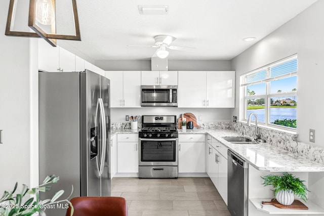 2102 Durban Ct, Rockledge, FL 32955 - kitchen with stainless steel appliances, a sink, a ceiling fan, light stone countertops, and white cabinetry