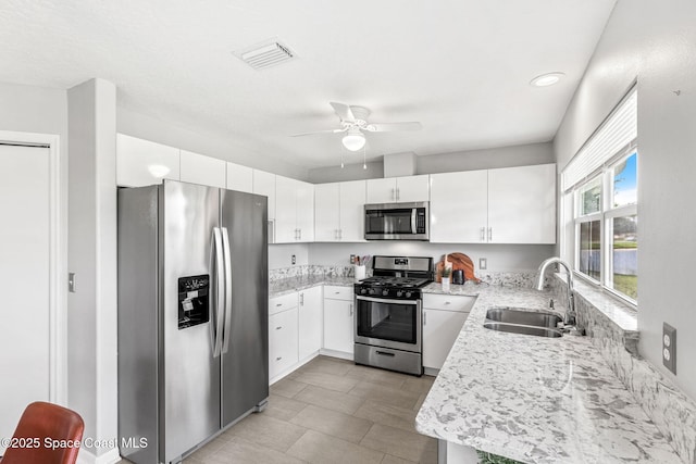 2102 Durban Ct, Rockledge, FL 32955 - kitchen featuring appliances with stainless steel finishes, a sink, a ceiling fan, white cabinets, and light stone counters