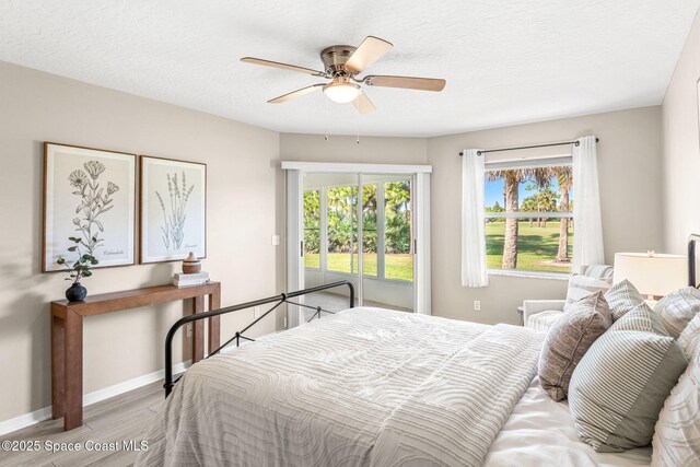2102 Durban Ct, Rockledge, FL 32955 - bedroom with wood finished floors, multiple windows, baseboards, access to outside, and a textured ceiling