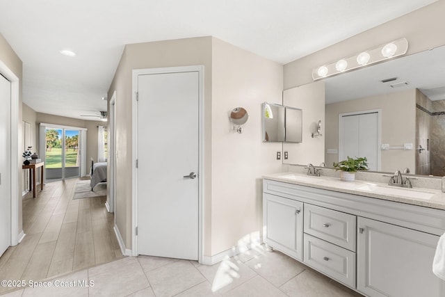 2102 Durban Ct, Rockledge, FL 32955 - ensuite bathroom with double vanity, a ceiling fan, baseboards, and tiled shower