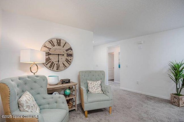 living area featuring carpet flooring and baseboards