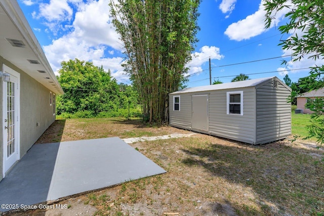 129 Irvine Ave SE, Palm Bay, FL 32909 - view of yard featuring a patio area, an outbuilding, and a storage unit