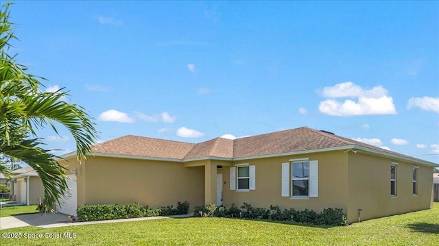 ranch-style house with stucco siding, concrete driveway, a front lawn, a garage, and roof with shingles