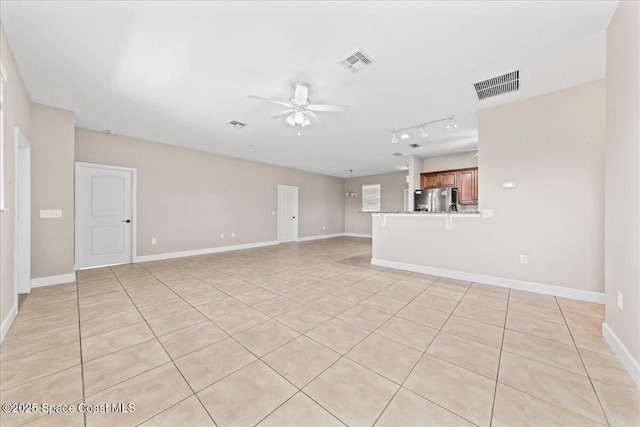 unfurnished living room featuring a ceiling fan, light tile patterned floors, rail lighting, and baseboards