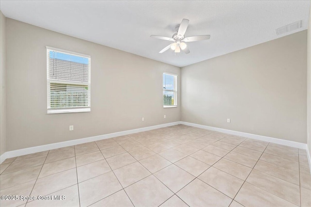 unfurnished room with ceiling fan, light tile patterned floors, and baseboards