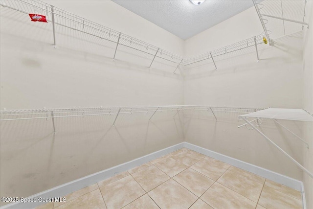 walk in closet with light tile patterned floors