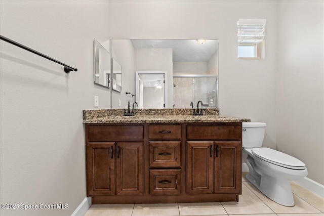 full bath with baseboards, toilet, a shower stall, and double vanity