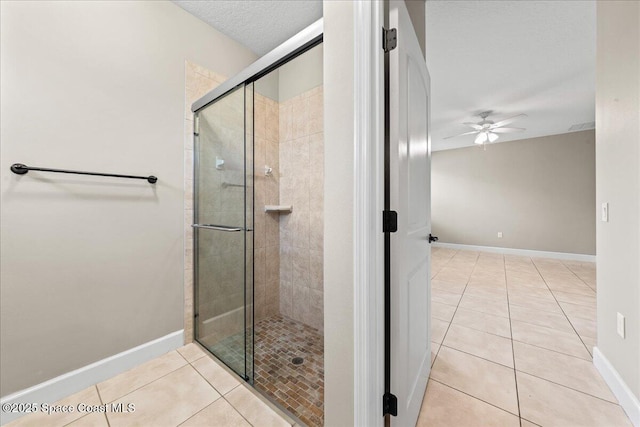 bathroom featuring tile patterned flooring, a ceiling fan, and a shower stall