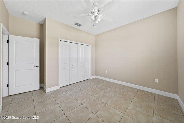 431 Cellini Ave NE, Palm Bay, FL 32907 - unfurnished bedroom with light tile patterned floors, a closet, and baseboards