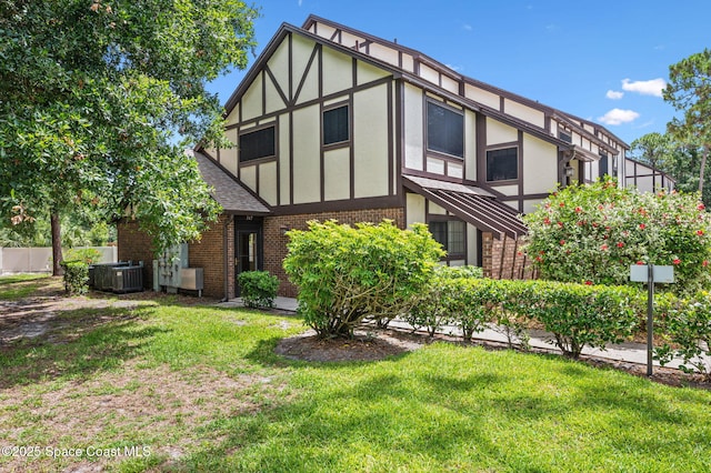 747 Greenwood Manor Cir Unit 17-A, West Melbourne, FL 32904 - rear view of house featuring brick siding, a shingled roof, stucco siding, and a lawn