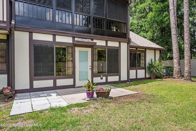 747 Greenwood Manor Cir Unit 17-A, West Melbourne, FL 32904 - back of house with stucco siding, a lawn, a patio area, and roof with shingles