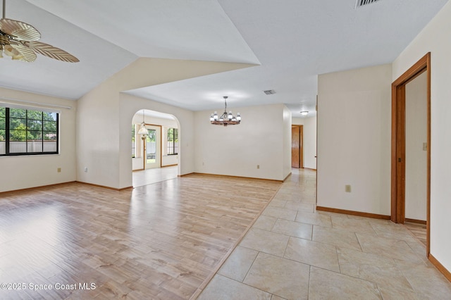 747 Greenwood Manor Cir Unit 17-A, West Melbourne, FL 32904 - empty room featuring a chandelier, healthy amount of natural light, a ceiling fan, arched walkways, and lofted ceiling