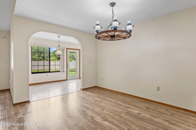 747 Greenwood Manor Cir Unit 17-A, West Melbourne, FL 32904 - spare room featuring arched walkways, a chandelier, and wood finished floors