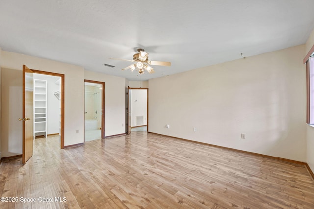 747 Greenwood Manor Cir Unit 17-A, West Melbourne, FL 32904 - unfurnished bedroom featuring a spacious closet, light wood finished floors, ensuite bathroom, a closet, and ceiling fan