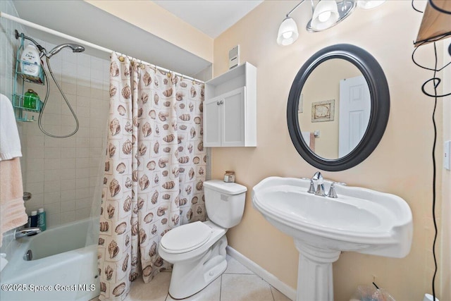 bathroom featuring tile patterned floors, toilet, shower / bath combo, and baseboards
