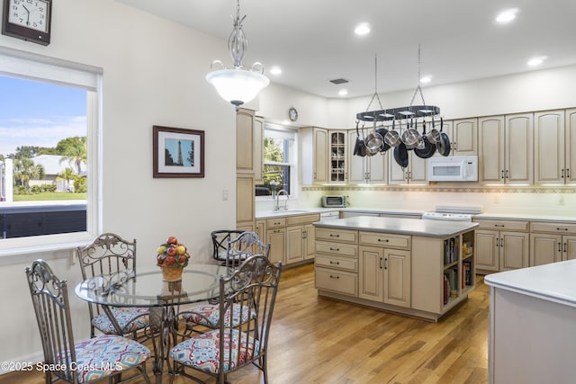 1035 Quail Ct SW, Vero Beach, FL 32968 - kitchen with white microwave, backsplash, light countertops, light wood finished floors, and recessed lighting