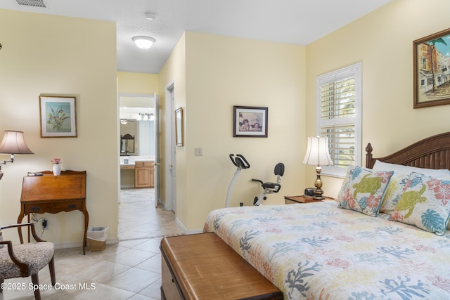 1035 Quail Ct SW, Vero Beach, FL 32968 - bedroom featuring light tile patterned floors, ensuite bathroom, and baseboards