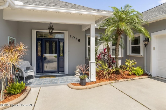 1035 Quail Ct SW, Vero Beach, FL 32968 - property entrance with roof with shingles, stucco siding, and covered porch