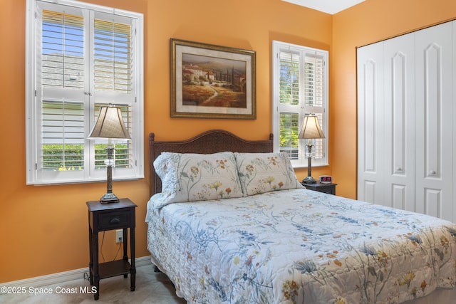 1035 Quail Ct SW, Vero Beach, FL 32968 - bedroom featuring multiple windows, a closet, and baseboards