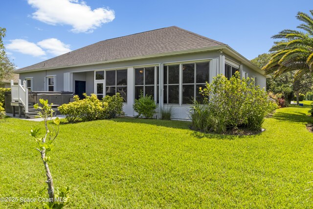 1035 Quail Ct SW, Vero Beach, FL 32968 - rear view of property with a hot tub, a lawn, and a shingled roof